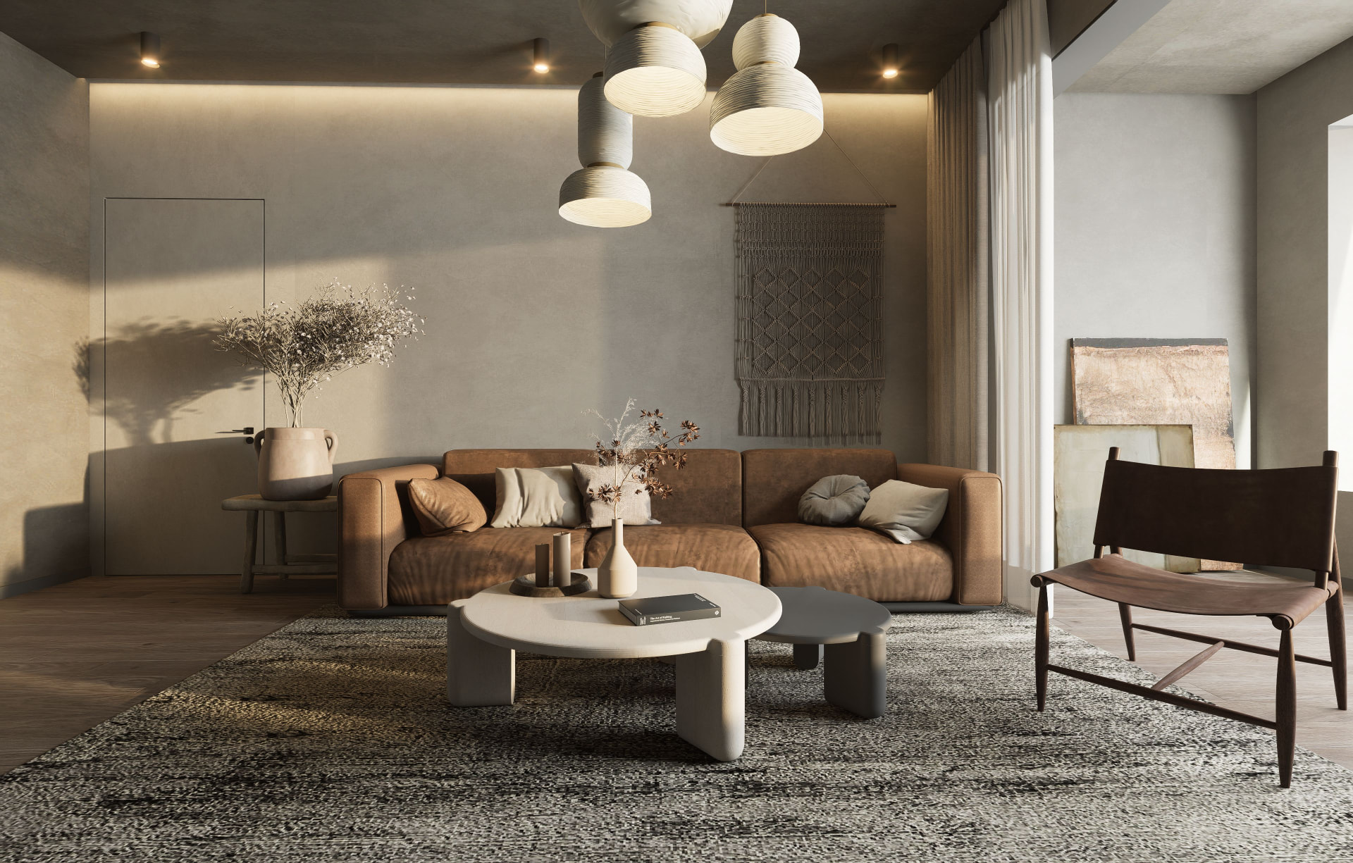 Woonkamer met een cognacbruine bank, een organisch vormde salontafel met kaarsen en droogbloemen, sculpturale hanglampen en een geweven wandkleed in warme aardetinten